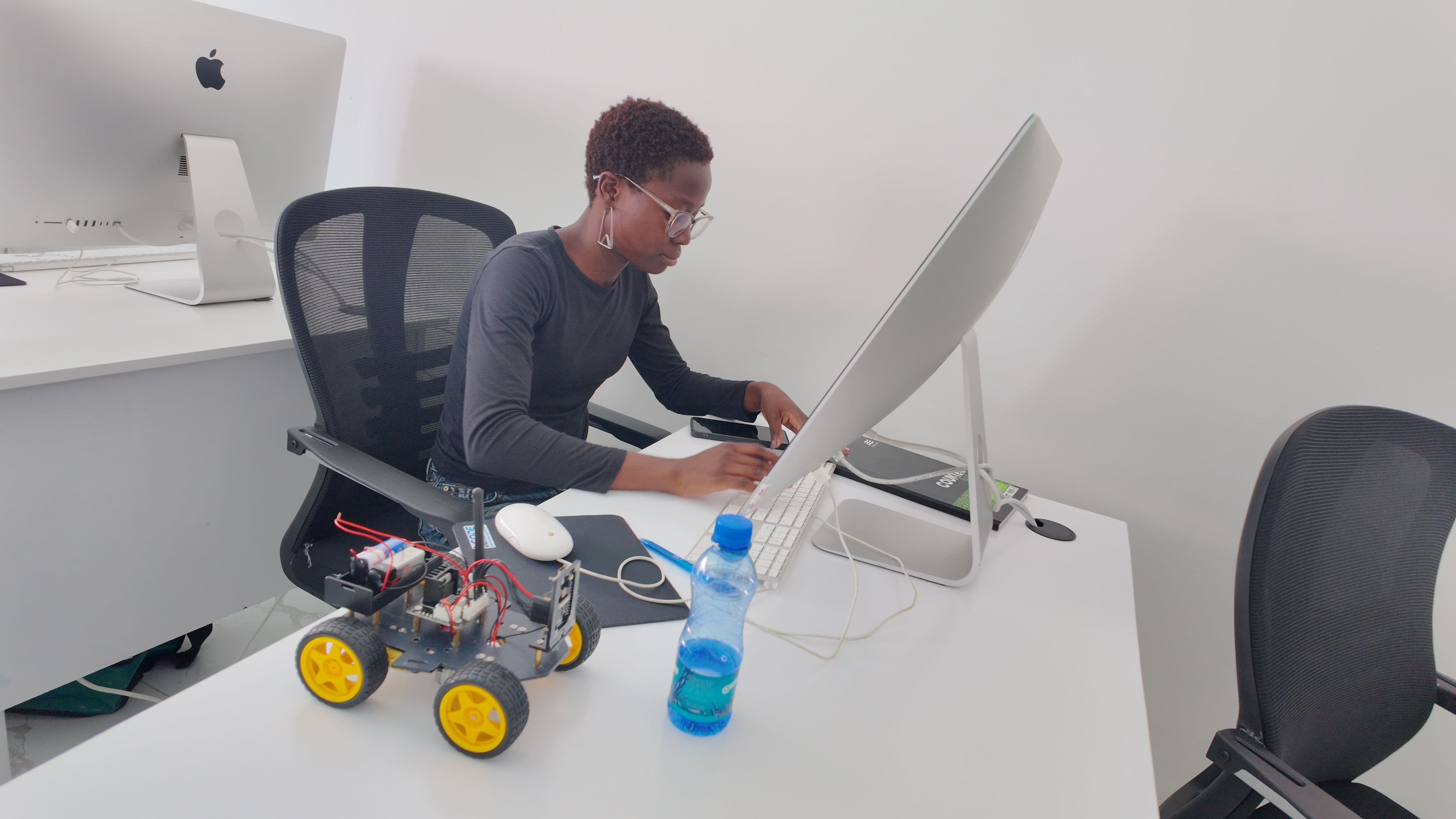 Female student programs Arduino robot car at the lab