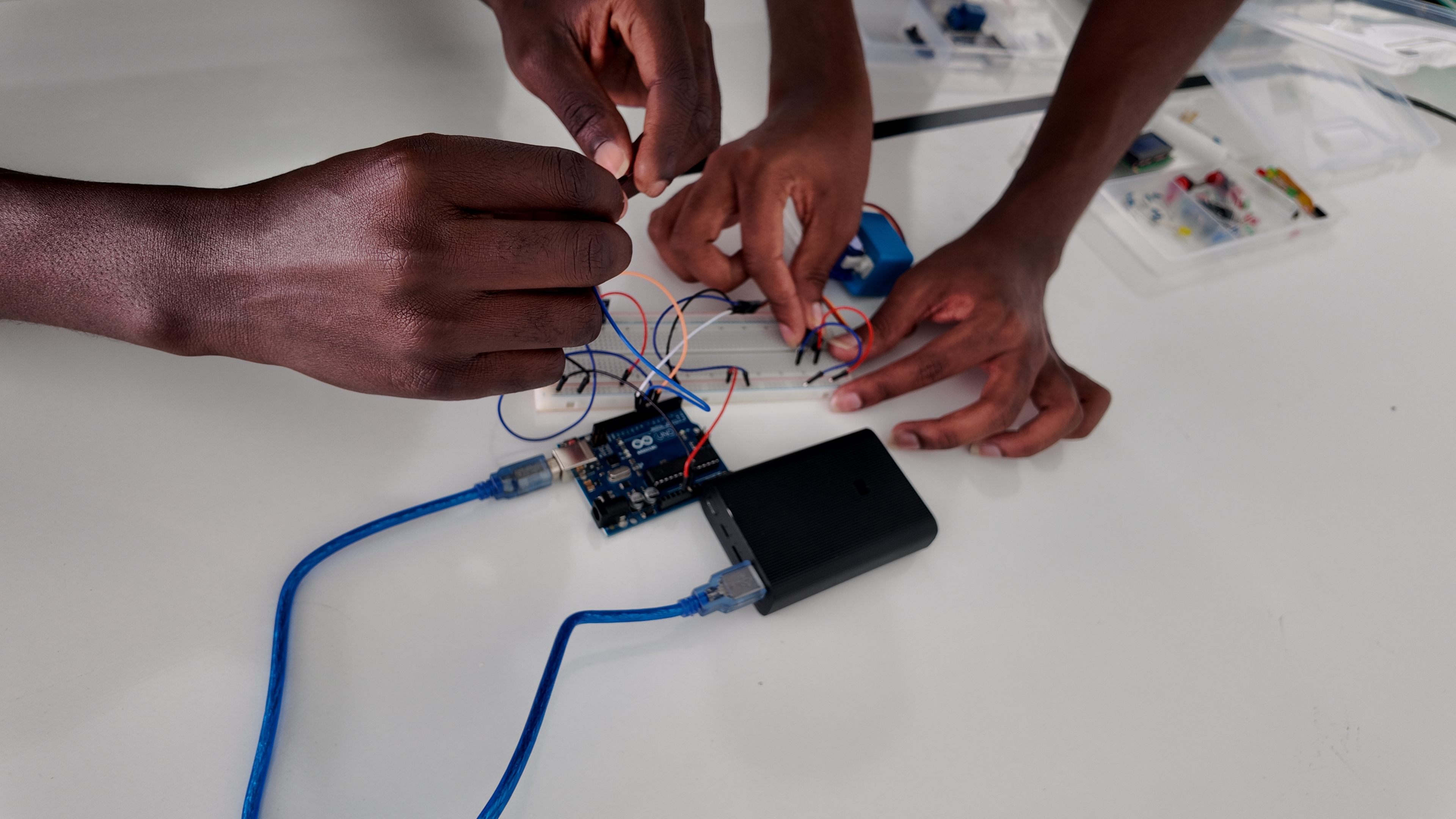 Hands deep in Arduino circuit wiring at i-CODE lab