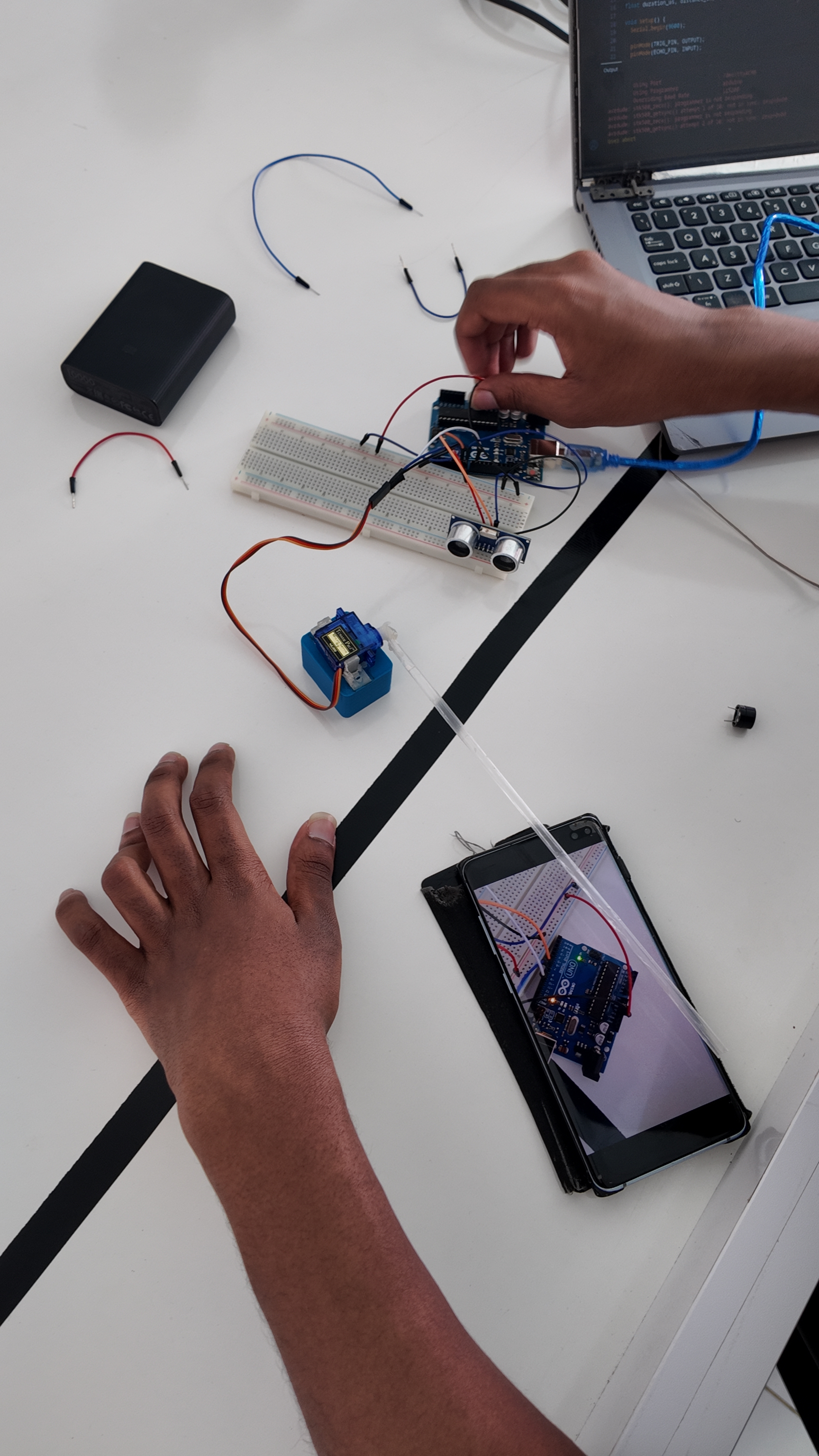 Student wiring Arduino smart barrier circuit on breadboard