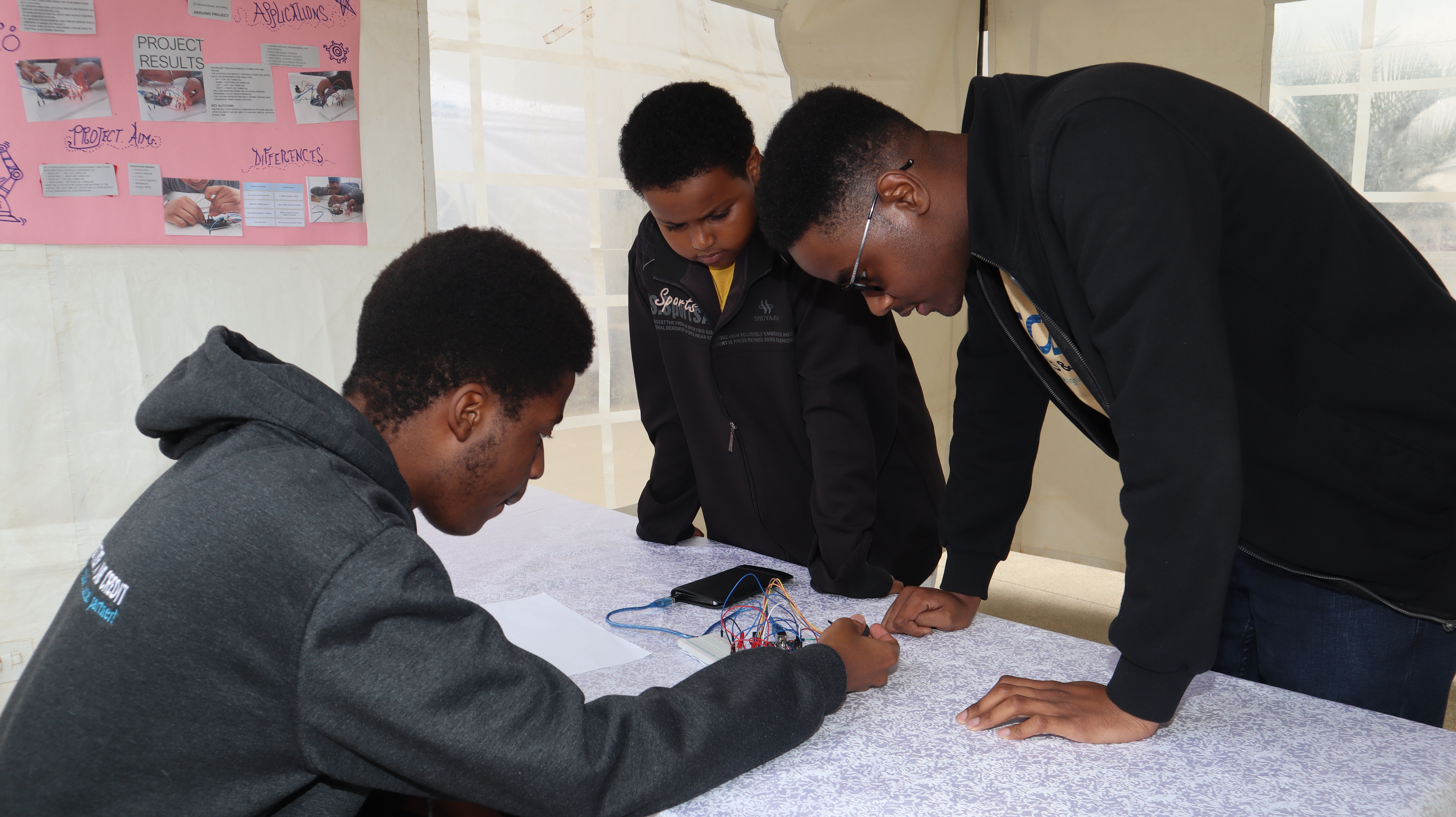 Students examine Arduino project circuit at i-CODE expo showcase