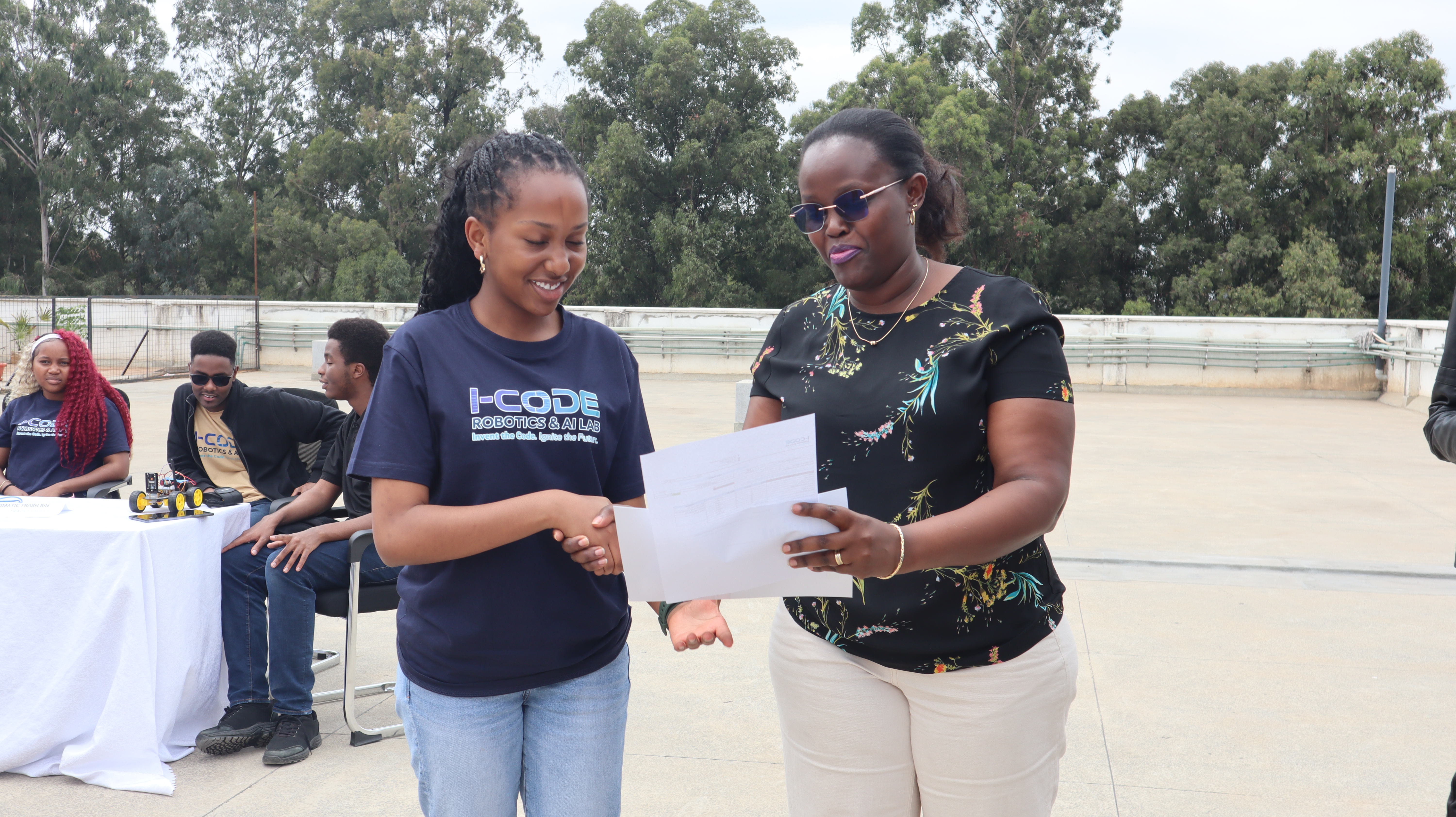 Student receives certificate at i-CODE Innovation Expo